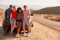 Young adult friends on a road trip take a break by their car Royalty Free Stock Photo
