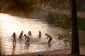 Young adult friends splashing and having fun in a lake