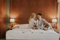 Young adult heterosexual couple on bed in bedroom Royalty Free Stock Photo