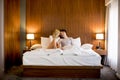 Young adult heterosexual couple on bed in bedroom Royalty Free Stock Photo