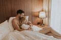 Young adult heterosexual couple on bed in bedroom Royalty Free Stock Photo