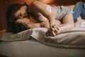 Young adult heterosexual couple lying on bed in bedroom