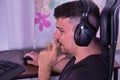 Young adult Hispanic male sitting at a computer with his hand on his chin concentrating on his work Royalty Free Stock Photo