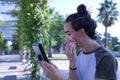 Young adult Hispanic transsexual girl doing her makeup in front of a hand mirror. Concept of transsexuality, inclusion and Royalty Free Stock Photo