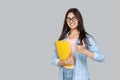 Young adult indian student girl showing thumb up, holding copybooks