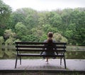 Lonely girl on a bench by the lake Royalty Free Stock Photo