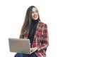 Young adult latin american womoan dressed formaly sitting with laptop computer on her lap looking sideways smiling