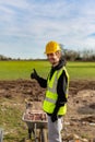 A young adult male builder wearing a high visibility vest and hard hat while giving a thumbs up Royalty Free Stock Photo