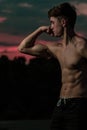 Young adult male flexing his muscles at twilight Royalty Free Stock Photo