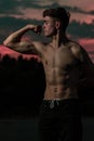 Young adult male flexing his muscles at twilight Royalty Free Stock Photo