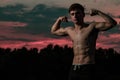 Young adult male flexing his muscles at twilight Royalty Free Stock Photo