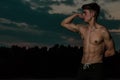 Young adult male flexing his muscles at twilight Royalty Free Stock Photo