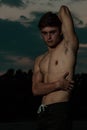 Young adult male flexing his muscles at twilight Royalty Free Stock Photo