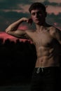 Young adult male flexing his muscles at twilight Royalty Free Stock Photo