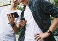Young adult male friends on the basketball court using smartphones millennials concept Royalty Free Stock Photo