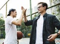 Young adult male friends playing basketball in the park