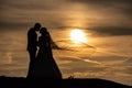 Young adult male groom and female bride holding hands on beach at sunset. Royalty Free Stock Photo