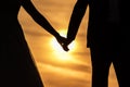 Young adult male groom and female bride holding hands on beach at sunset. Royalty Free Stock Photo