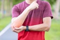 Young adult male with his muscle pain during exercise. Athlete man having elbow ache due to lateral epicondylitis or tennis elbow