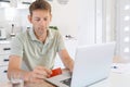 Young adult male shopping online with credit card using laptop at home. Man holding credit card and typing on computer Royalty Free Stock Photo