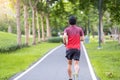 Young adult male in sportswear running in the park outdoor, runner man jogging on the road, asian Athlete walking and exercise in