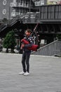 Young adult male wearing traditional attire holds a bagpipe