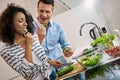 Young adult man and african american woman cooking healthy food together Royalty Free Stock Photo