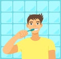 Young adult man brushing his teeth in bathroom. Teenager doing daily hygiene routine. Happy smiling boy.