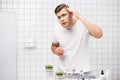 Young adult man checking hair, while Royalty Free Stock Photo