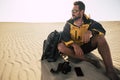 Young adult man explore desert sand dunes alone with backpack and photo camera. Photography landscape job activity with bearded Royalty Free Stock Photo