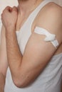 Close up shot of a man`s body: shoulder and arm with a bandage after rabies vaccination