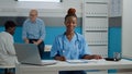 Young adult nurse sitting at desk with laptop