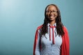 Young adult optimistic and strong superhero woman wearing hero cloak