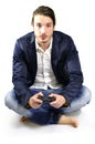 Young adult playing video game, sitting indoors, holding controller or joystick