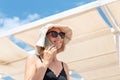 Young adult pretty attractive woman wear bikini, hat sunglasses enjoy smiling talking phone at tropical resort against Royalty Free Stock Photo