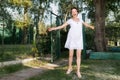 Young adult pretty caucasian happy woman in white dress having fun enjoy spin and dancing after quarantine lockdown Royalty Free Stock Photo