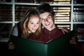 Young adult reading magic book in library Royalty Free Stock Photo