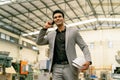 Young 20s Indian Asian factory businessman in formal suit walking talking on the phone. Successful business executive Royalty Free Stock Photo