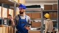 Young adult scanning barcodes on boxes in warehouse