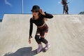 Cool young roller blader female skating in a concrete skate pool in a sunny summer day. Aggressive inline skater person riding in Royalty Free Stock Photo