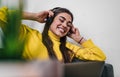 Young adult smiling cheerful girl woman listening to music from smartphone wearing wireless headset headphones while lying down on Royalty Free Stock Photo