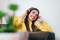 Young adult smiling cheerful girl woman listening to music from smartphone wearing wireless headset headphones while lying down on Royalty Free Stock Photo