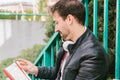 Young adult studying with a book in the street outdoors