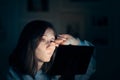 Tired Woman Rubbing Her Eyes Holding Tablet Sitting in Bed Royalty Free Stock Photo