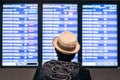 Young adult tourist traveler backpaker looking at airport flight schedule timetable on the screen Royalty Free Stock Photo