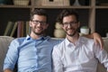 Millennial twins brothers smiling, looking at camera posing indoors