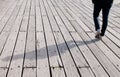 Young adult walking on a wooden footpath