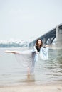 Young adult white female woman on a beach doing arabesque in the water Royalty Free Stock Photo