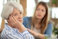 young adult woman consoles sad senior adult female Royalty Free Stock Photo