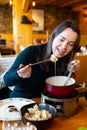 Young adult woman eating fondue at restaurant Royalty Free Stock Photo